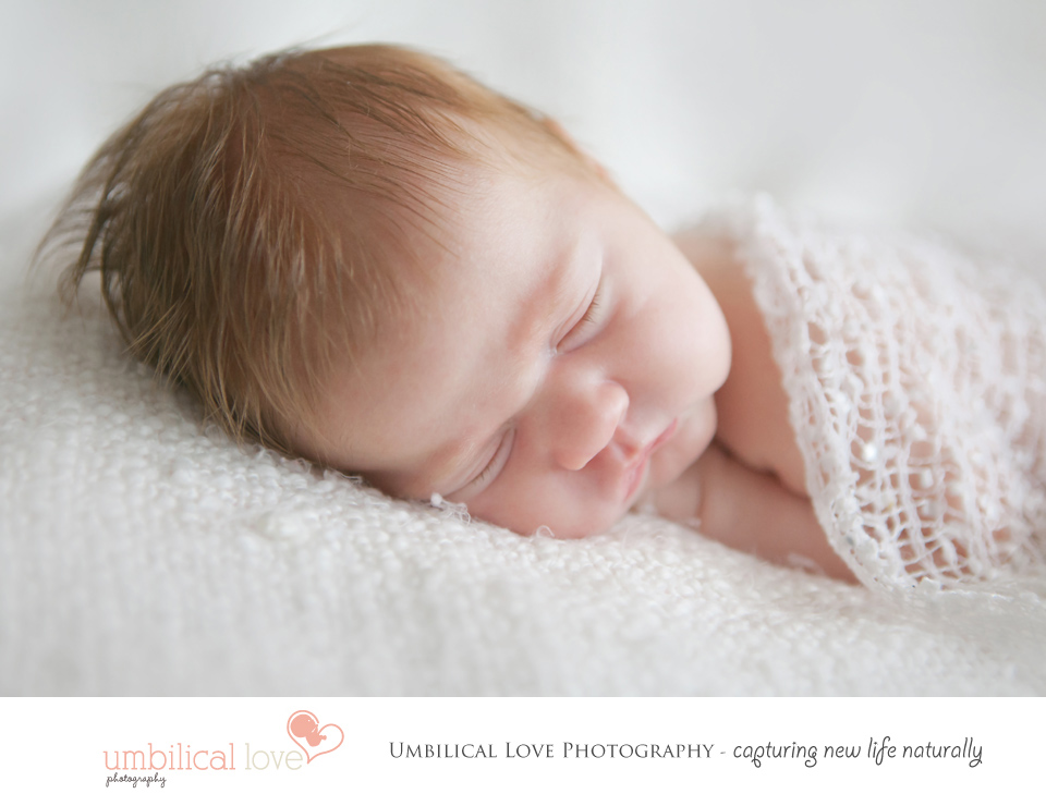 beautiful newborn baby girl sleeping with a lacy wrap on
