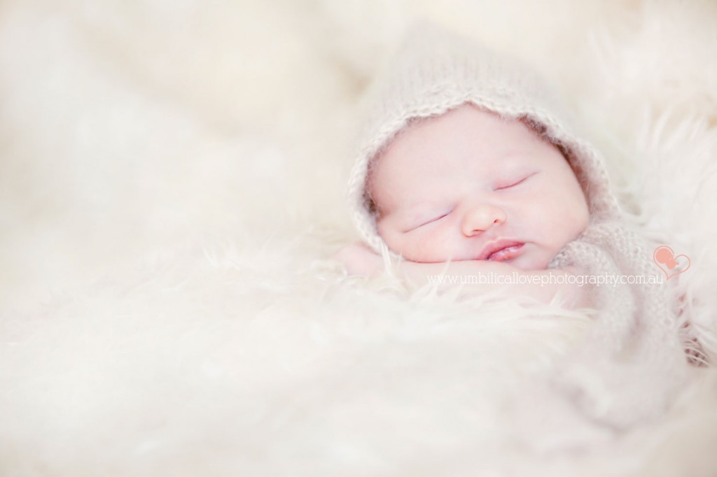 sweet new baby sleeping with a fine knitted bonnet on her head