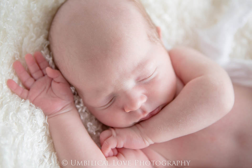 baby sleeping on his hand wrapped up