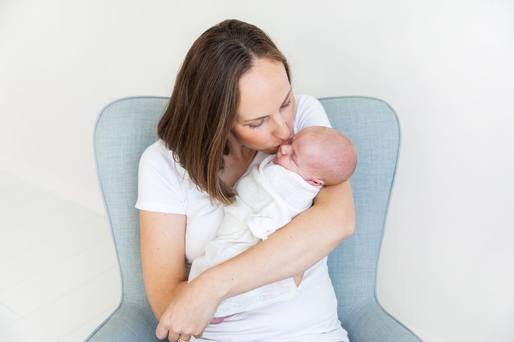 Mum gives her newborn baby a kiss